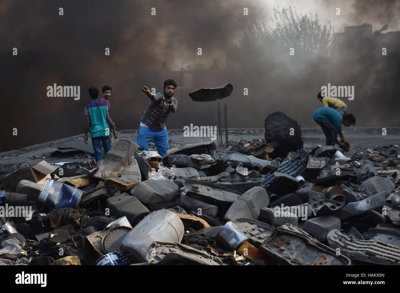 Pakistani workers Workers salvage factory material after fire erupted