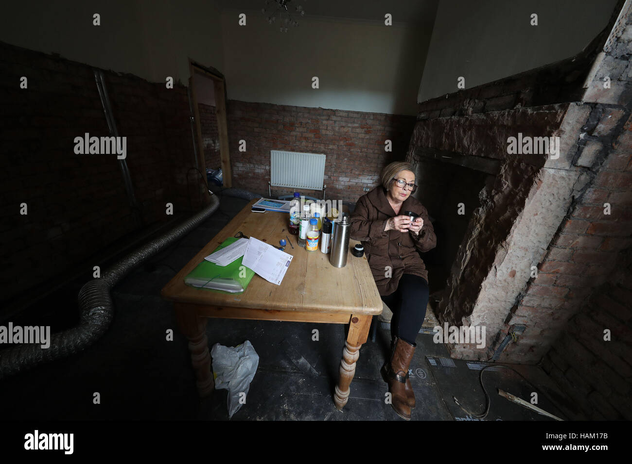 Pensioner Anne Reay from Warwick Road in Carlisle sits in the ruins of her home - one of hundreds of people facing another miserable festive season a year on from Storm Desmond. Stock Photo