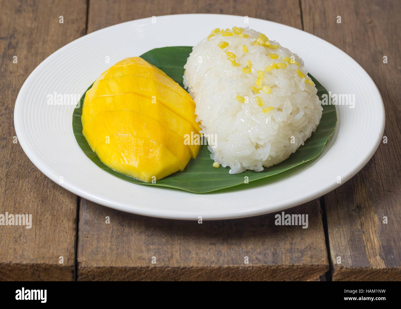 mango sticky rice with peeled split mung bean on white plate Stock