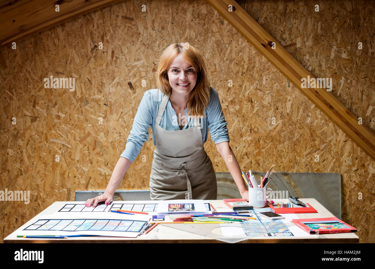 Portrait smiling stained glass artist working in studio Stock Photo