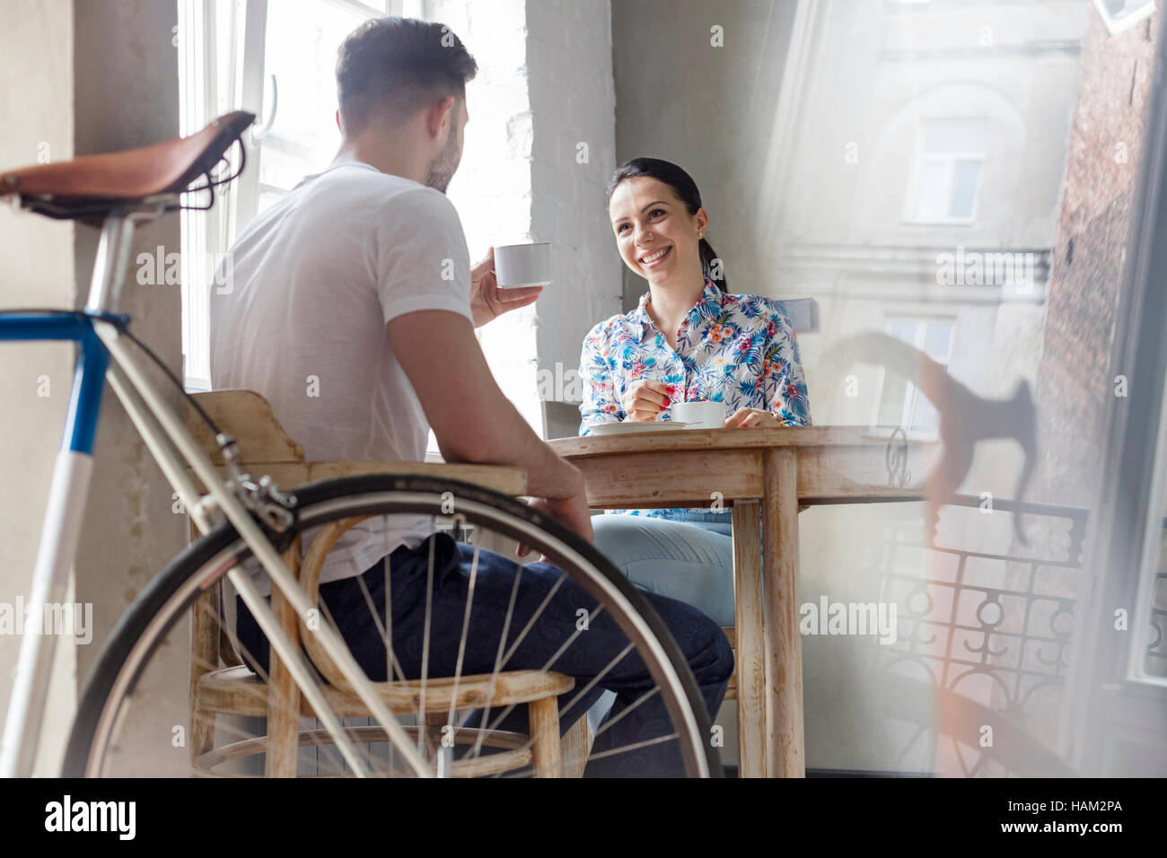 Couple drinking coffee and talking at table Stock Photo