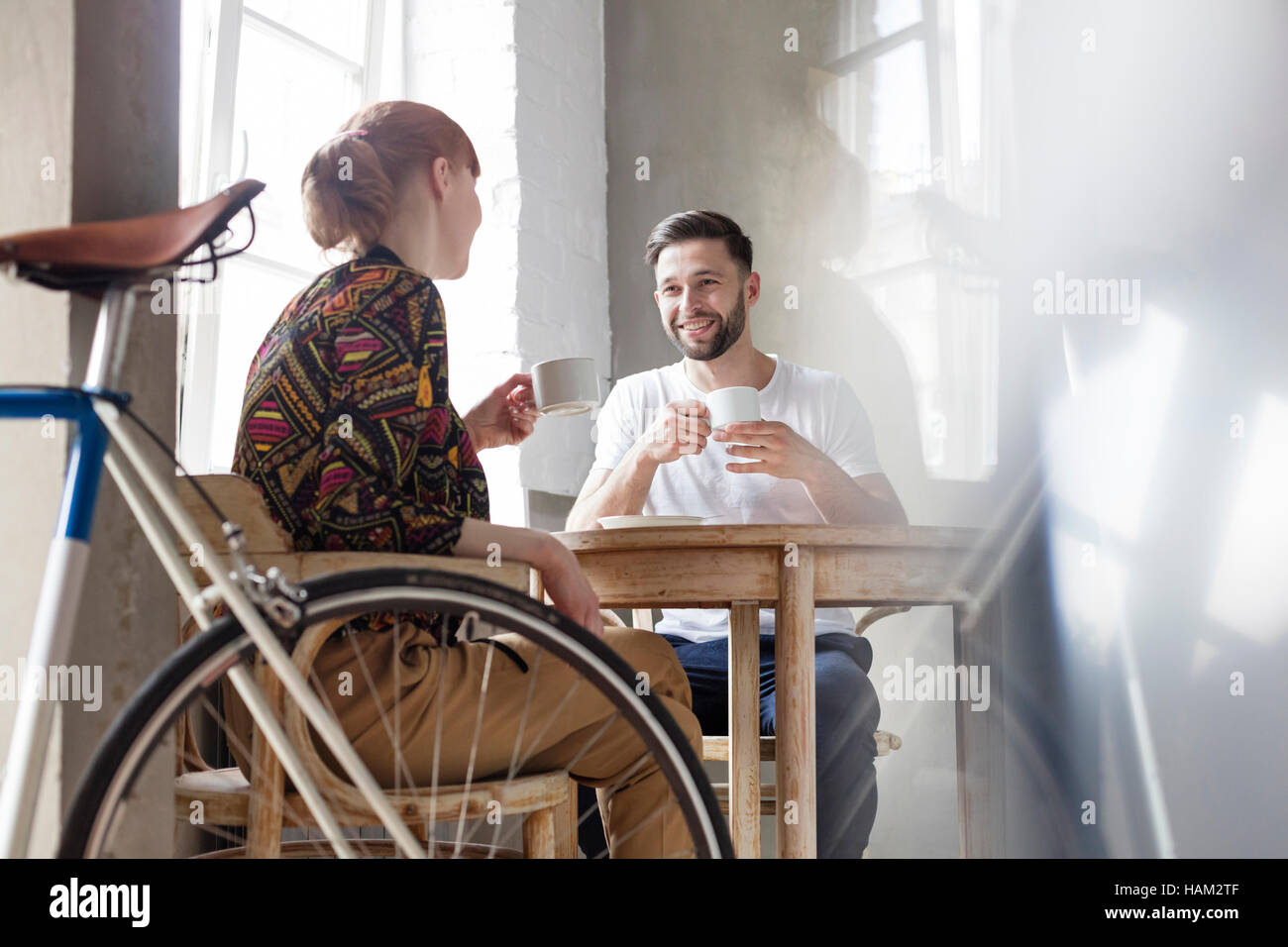 Couple talking and drinking coffee at table Stock Photo
