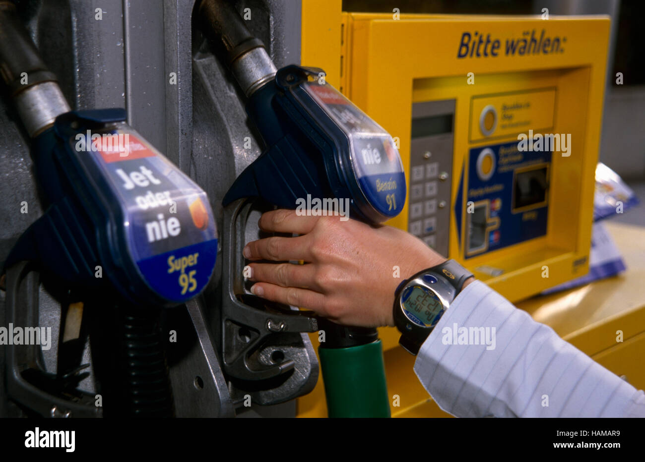 Hand removing the nozzle of the petrol pump ready to fill the car's tank, Steyr, Upper Austria, Europe Stock Photo