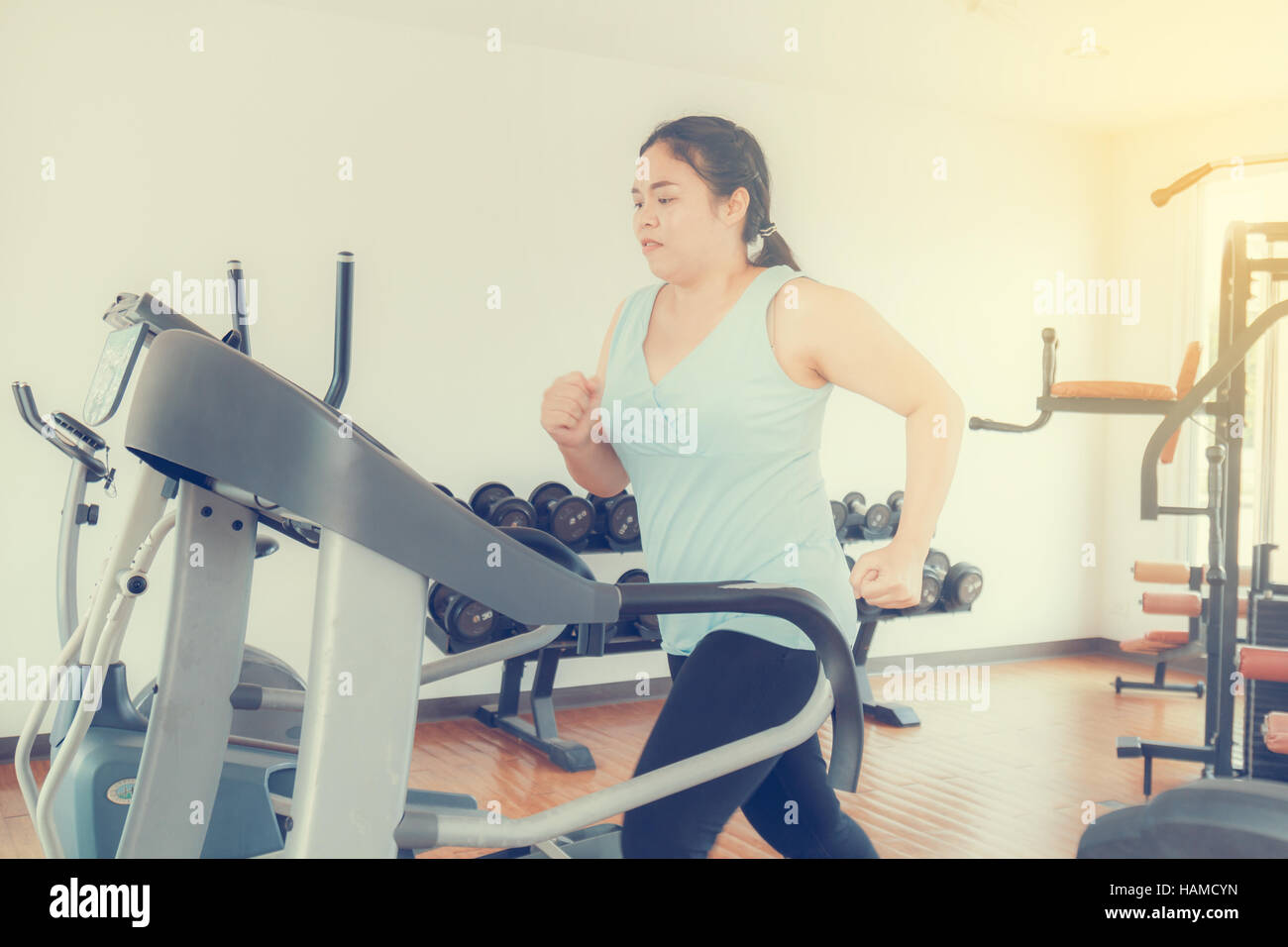 Asia fat woman run electric treadmill in the gym for strength, weight loss. Stock Photo