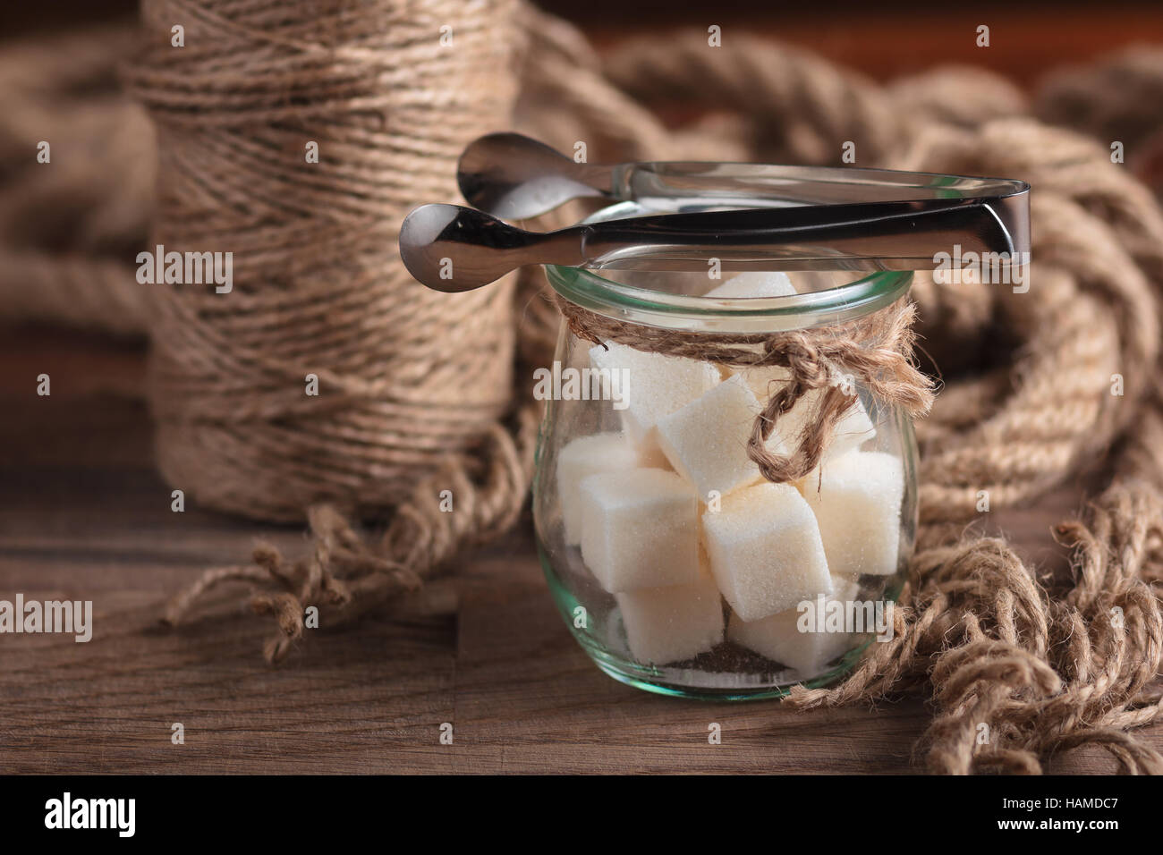 Concept: restaurant menus, healthy eating, homemade, gourmands, gluttony. Sugar in glass vintage jar on weathered wooden table. Stock Photo