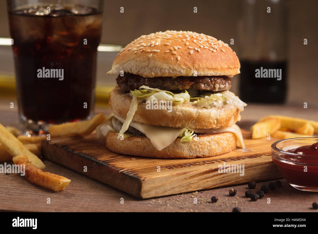 Concept: restaurant menus, healthy eating, homemade, gourmands, gluttony. Classic beef double burger with ingredients, drinks and french fries on mess Stock Photo