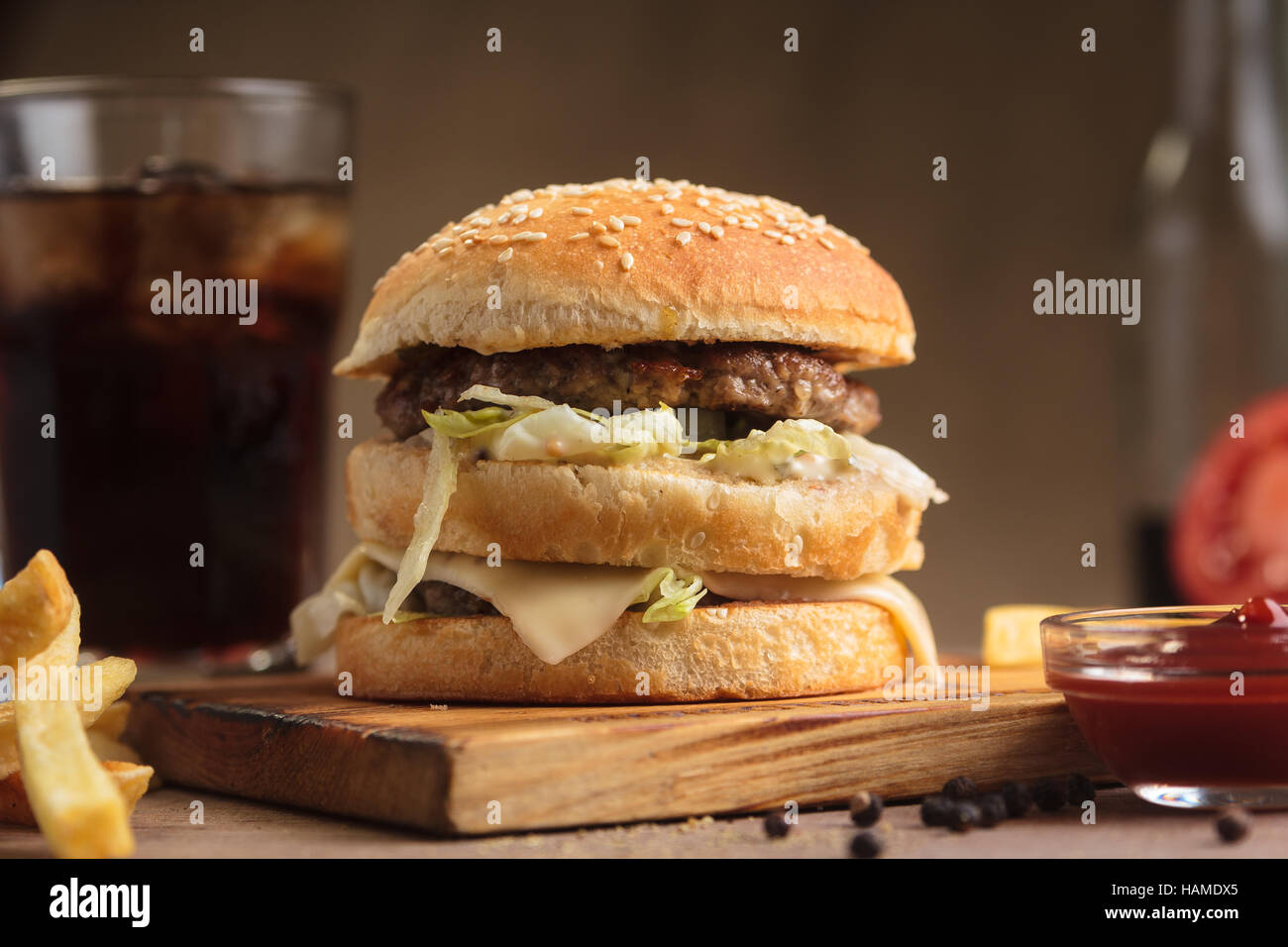 Concept: restaurant menus, healthy eating, homemade, gourmands, gluttony. Classic beef double burger with ingredients, drinks and french fries on mess Stock Photo