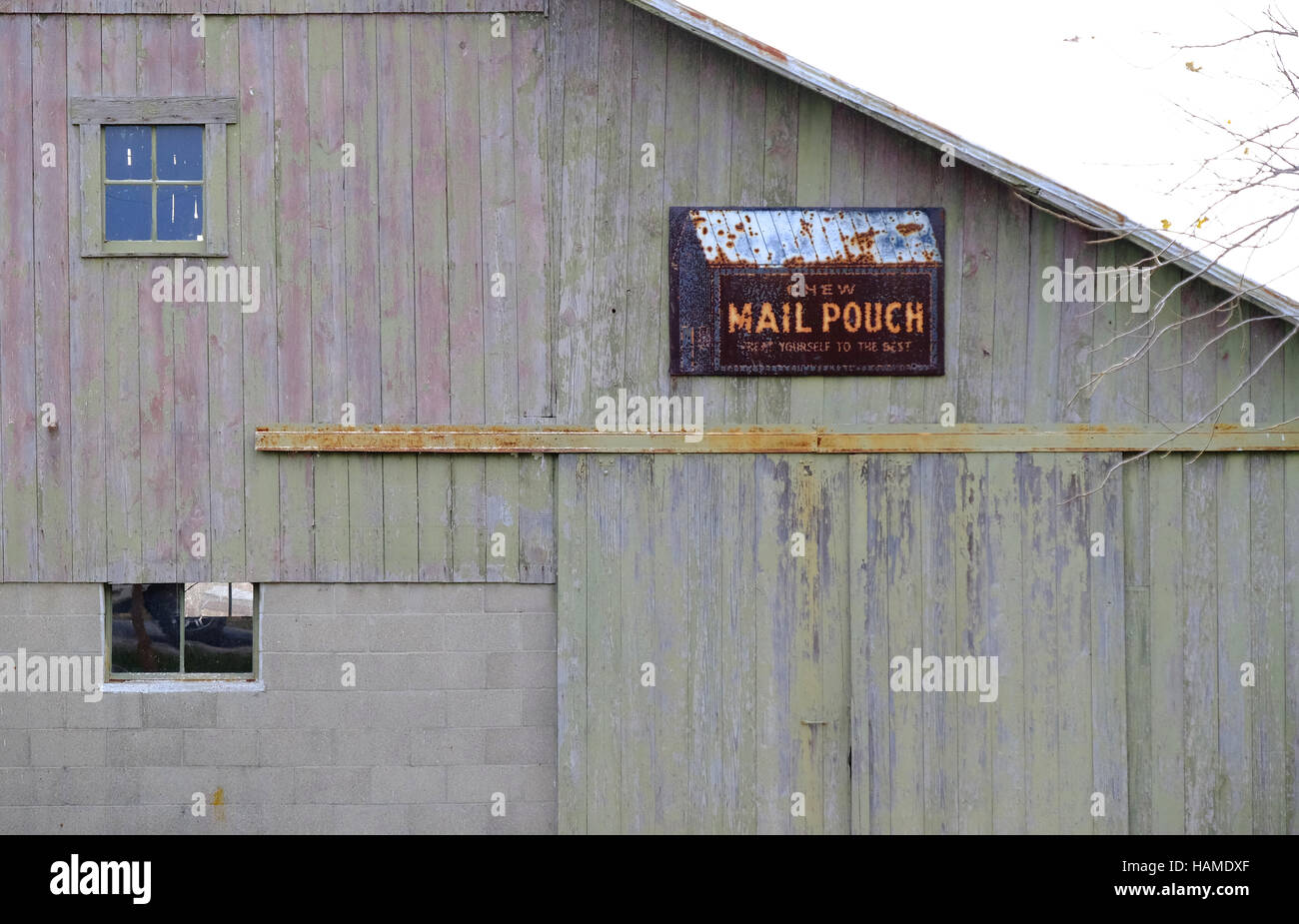 A Mail Pouch tobacco sign is rusting away on the side of a barn in central Indiana. Stock Photo