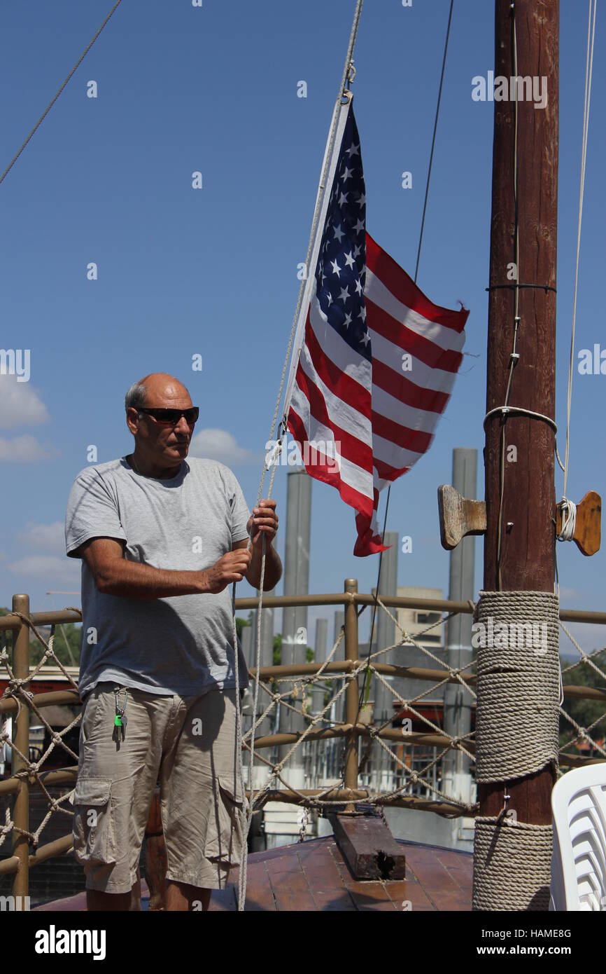 The captain of the Faith Boat raises the flag of the United States of America on the Sea of Galilee in Israel, 2016. Stock Photo