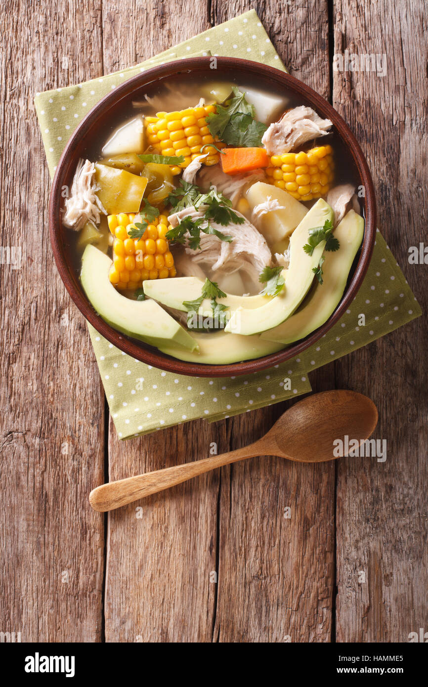 Traditional Colombian ajiaco soup close up in a bowl on the table. vertical view from above Stock Photo