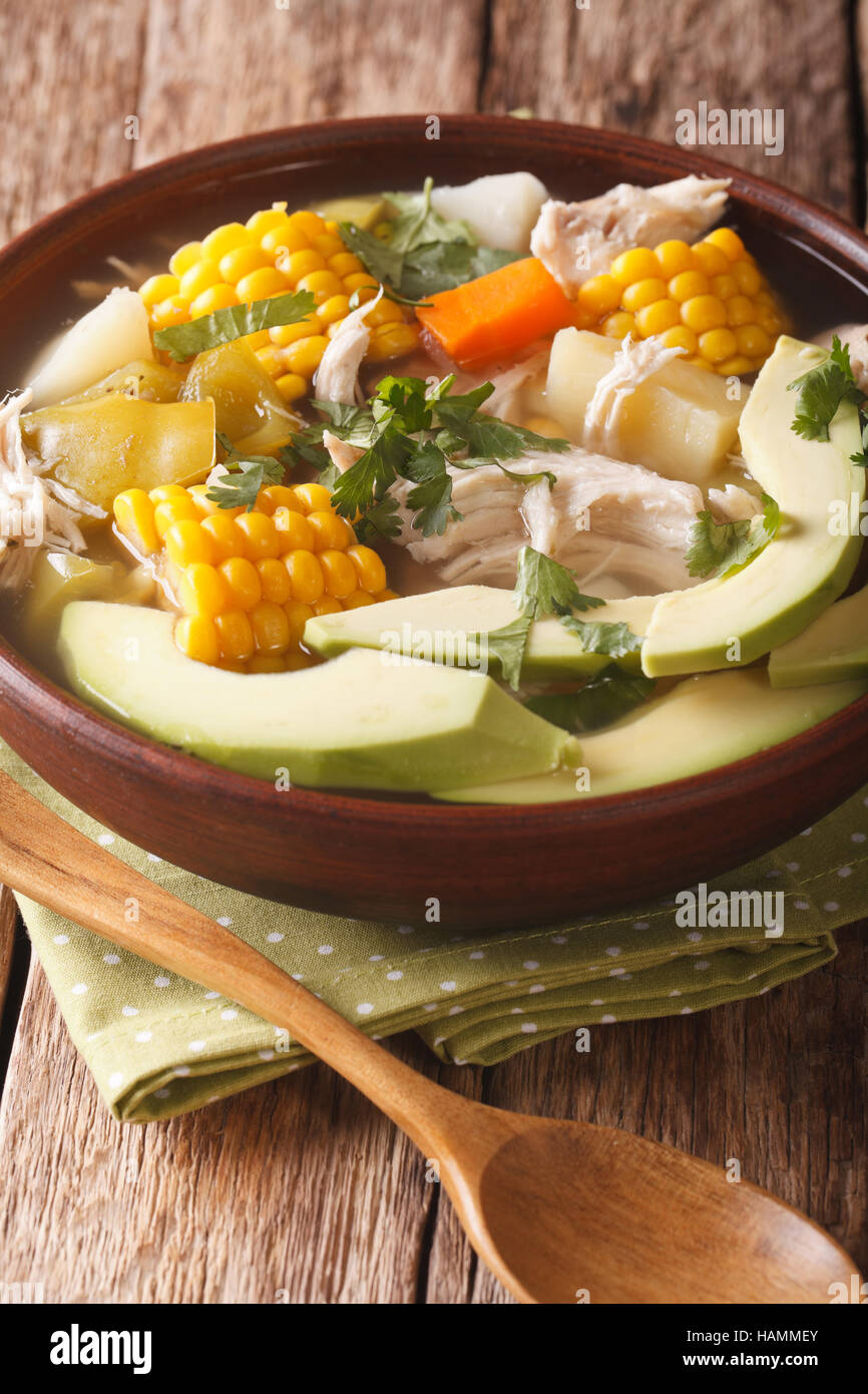 Potato soup ajiaco with chicken close up in a bowl on the table. Vertical Stock Photo