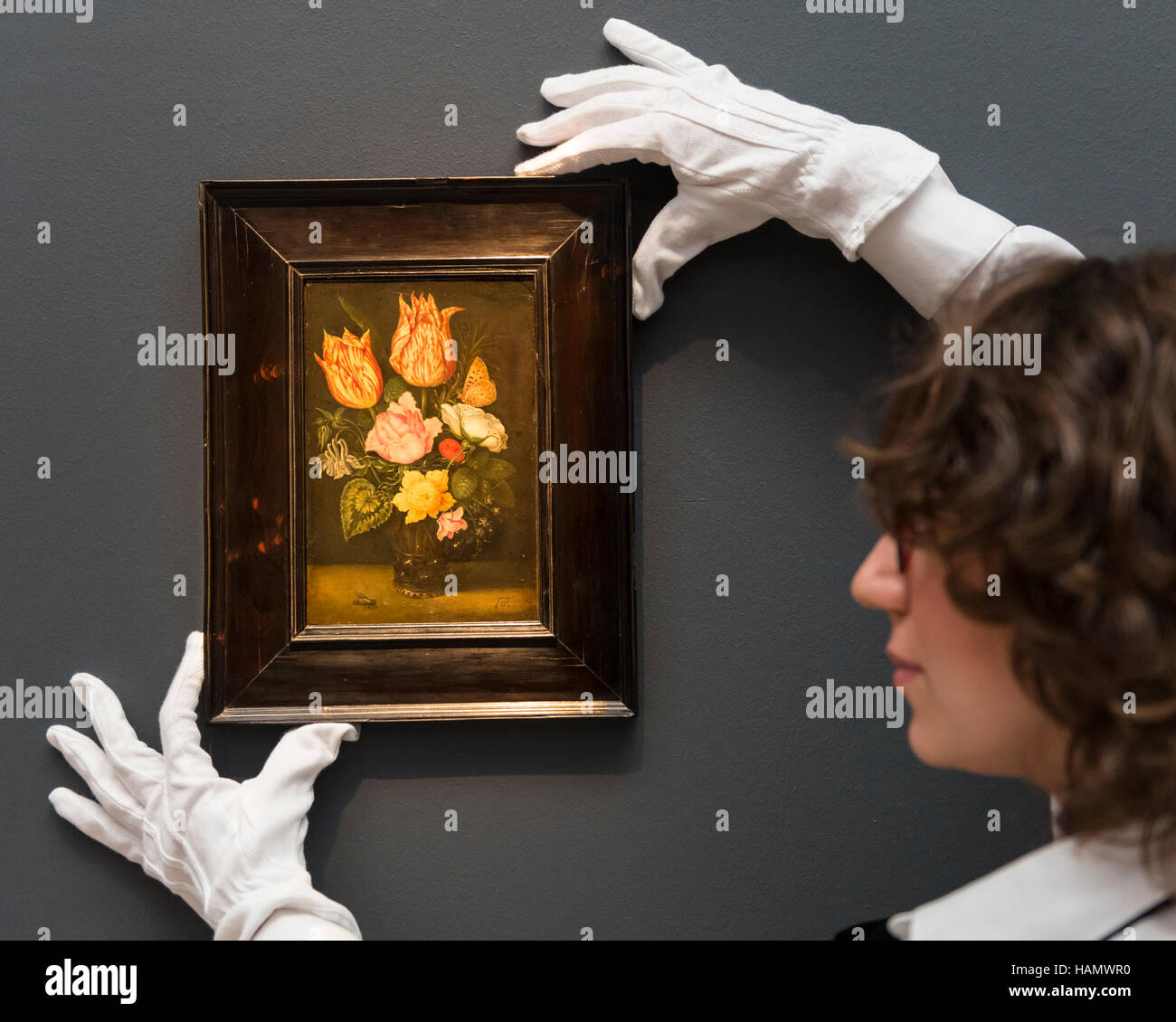 London, UK.  2 December 2016. A technician shows 'Still life of tulips, wild roses, cyclamen, yellow ranunculus, forget-me-not and other flowers, in a glass beaker' by Ambrosius Bosschaert the Elder (est. GBP0.9-1.2m), at a preview of Sotheby's upcoming Old Masters Evening Sale in New Bond Street.  Credit:  Stephen Chung / Alamy Live News Stock Photo