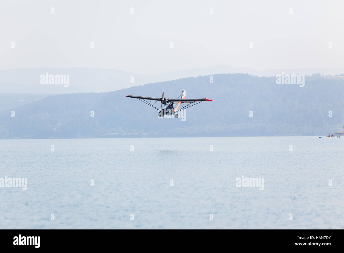 Plane Microlight pilot low flying aircraft photo over lake waters ...