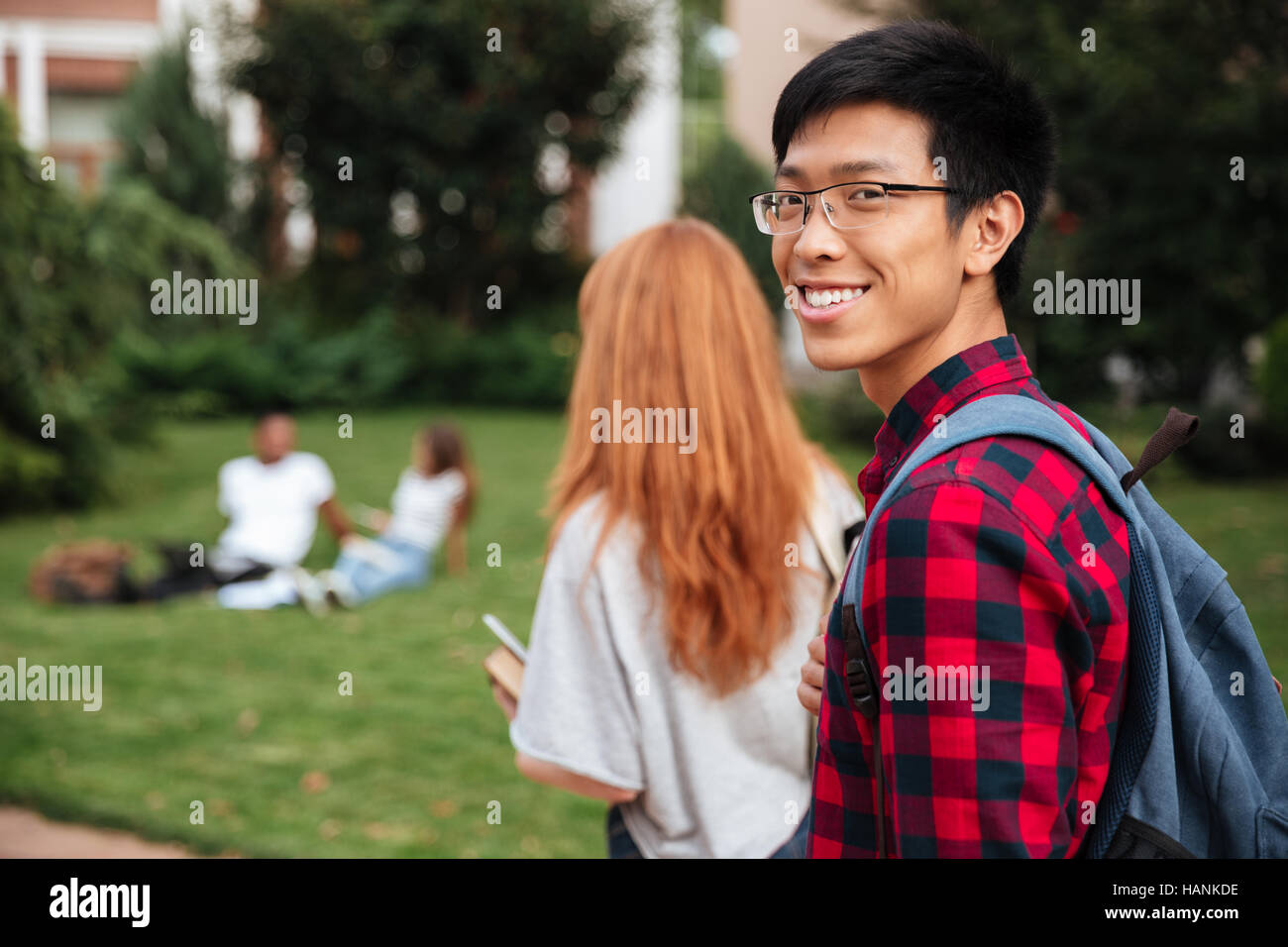 Happy asian young man student with backpack walking outdoors Stock ...