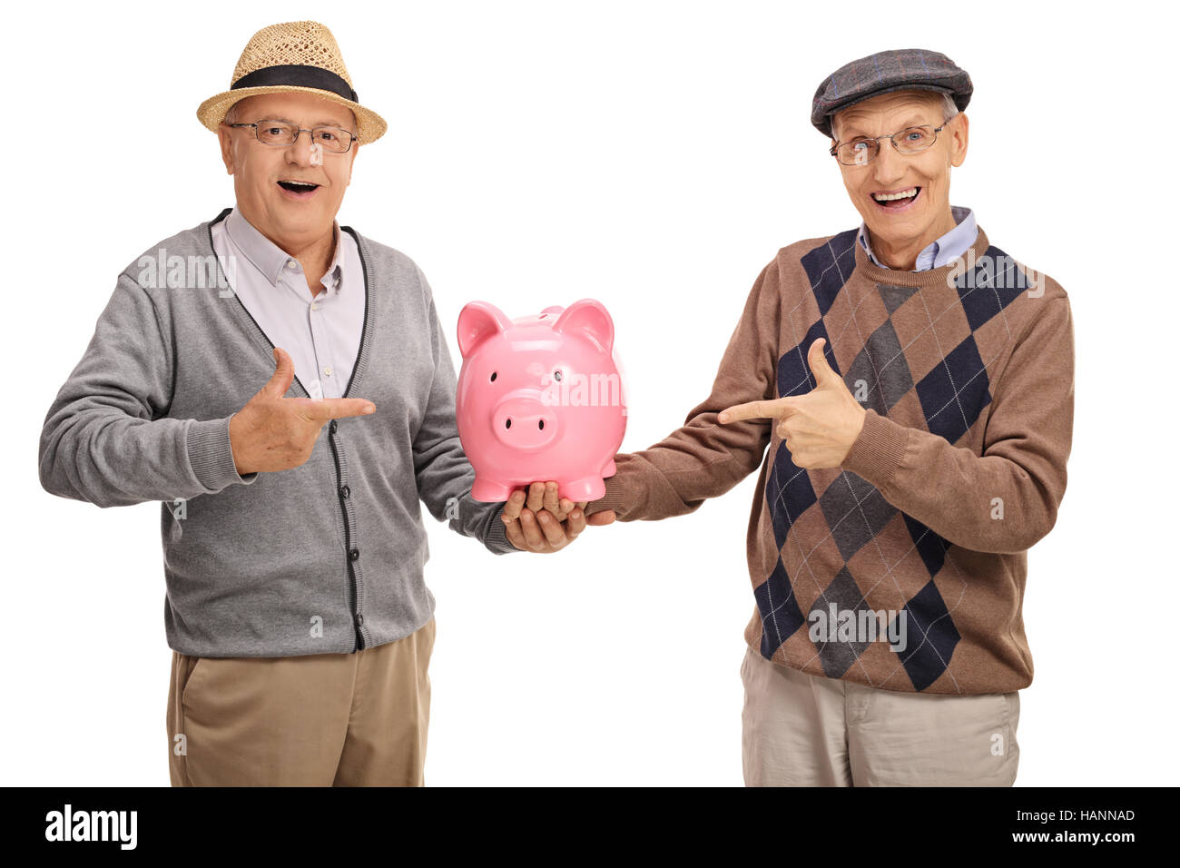Happy seniors holding a piggybank and pointing isolated on white background Stock Photo