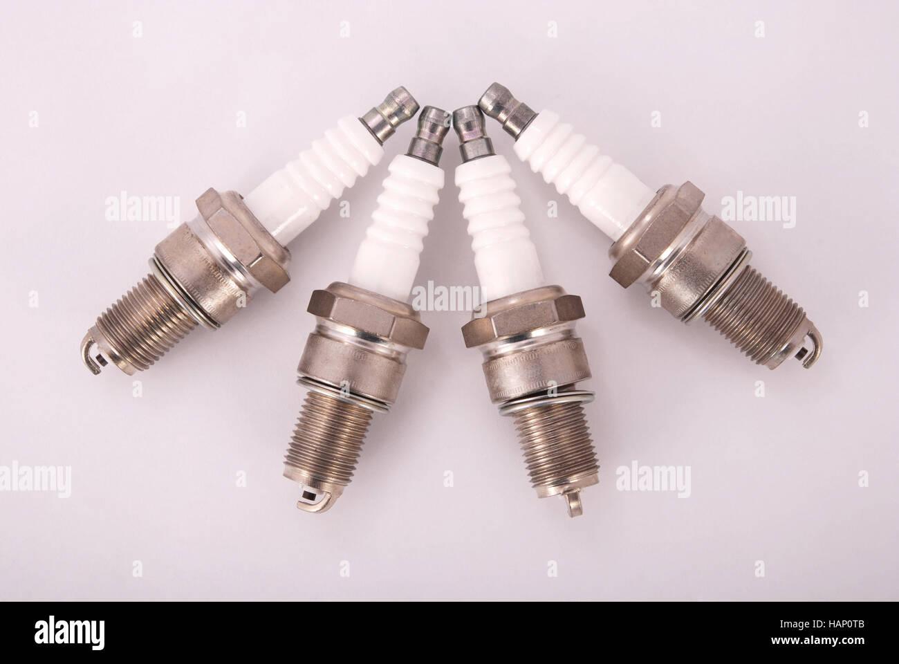 Four new spark plugs on a gray background Stock Photo Alamy