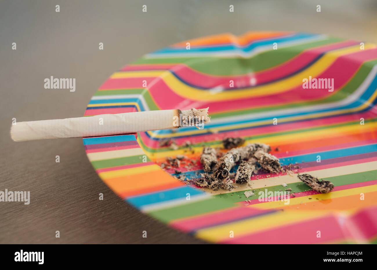 Cigarette in the colorful ashtray Stock Photo