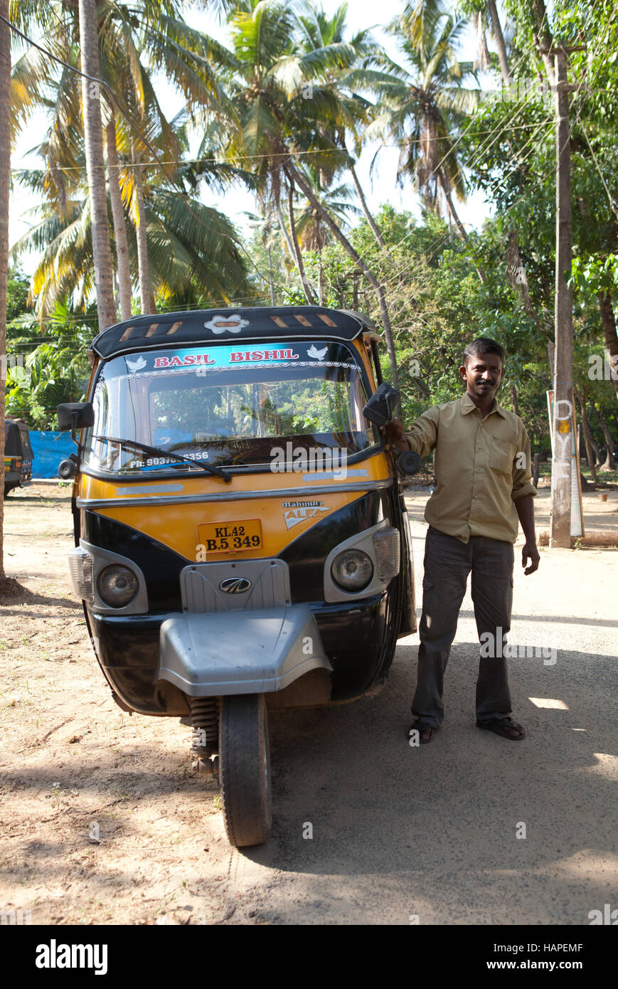Driver standing next to his auto rickshaw taxi in Cherai Beach, India Stock Photo