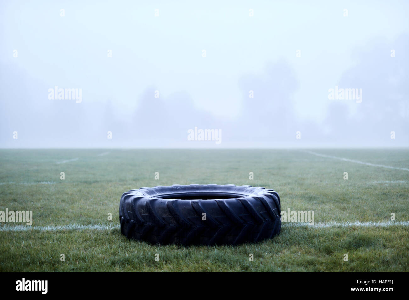 Rubber tire on foggy football field Stock Photo
