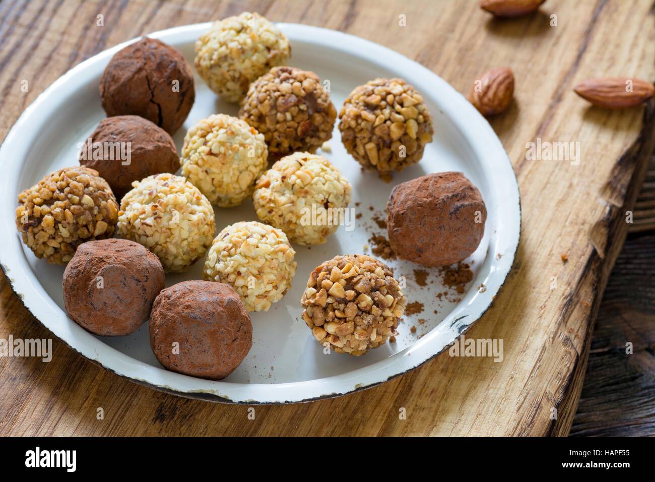 Vegan chocolate truffles covered with cocoa powder and different nuts
