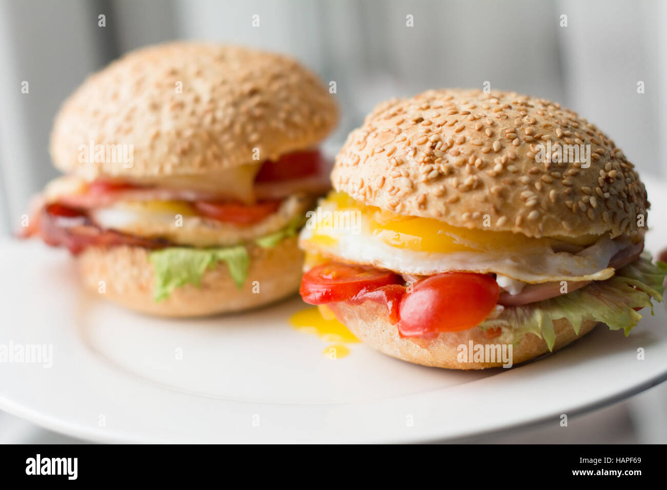Bacon, egg and tomato sandwiches on white plate, close up view Stock ...