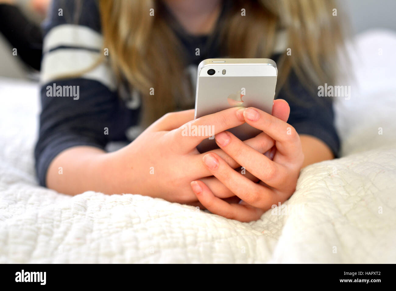 Teen / tween girl holding a mobile phone (iphone) Stock Photo