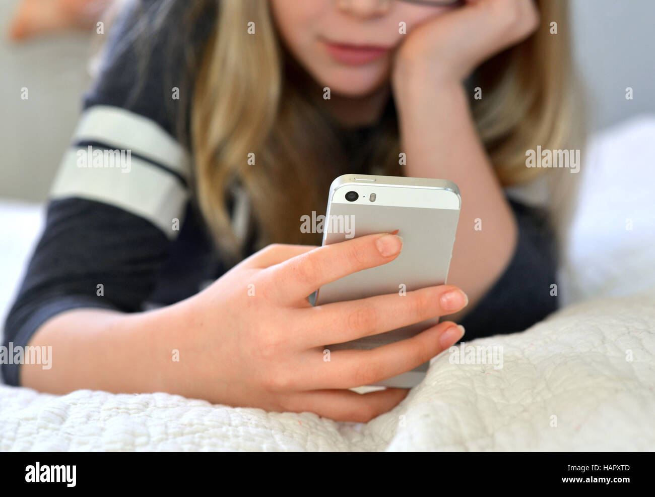 Teen / tween girl holding a mobile phone (iphone) Stock Photo