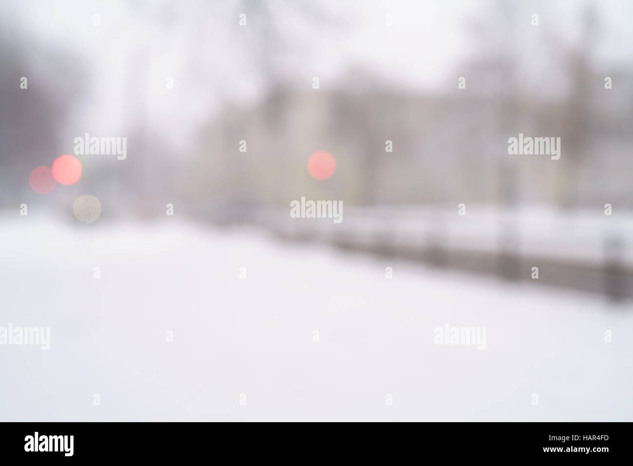 snowfall in town with blurred moving cars on background Stock Photo