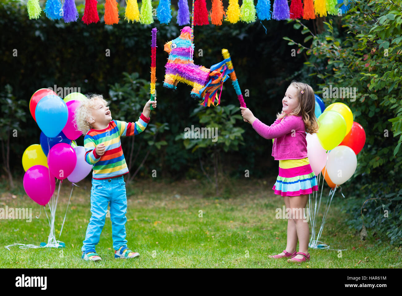 Kids birthday party. Group of children hitting pinata and playing with  balloons. Family and friends celebrating birthday outdoors in decorated  garden Stock Photo - Alamy