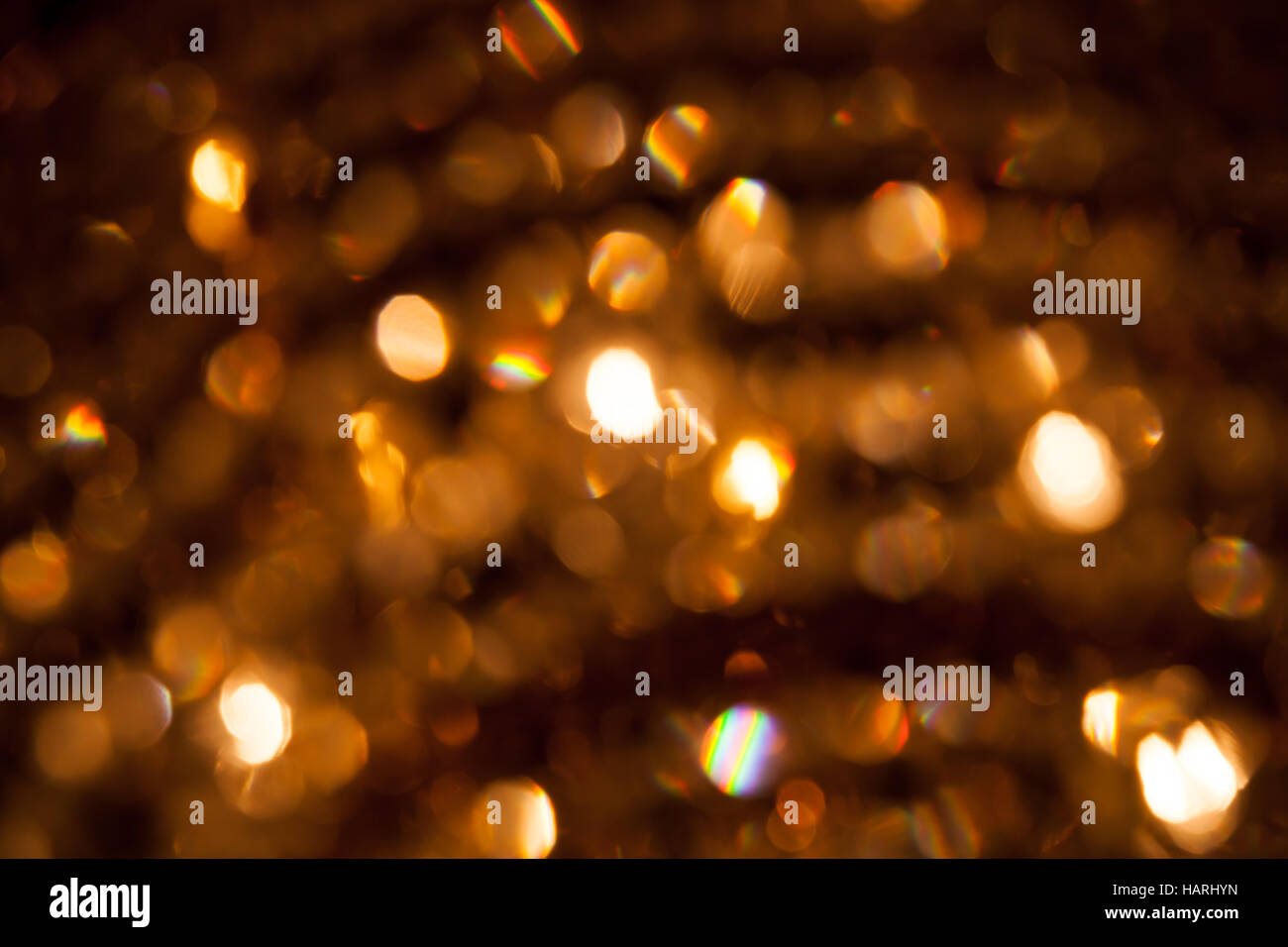 Defocused abstract golden lights background. Natural bokeh photo with rainbow refraction patterns Stock Photo
