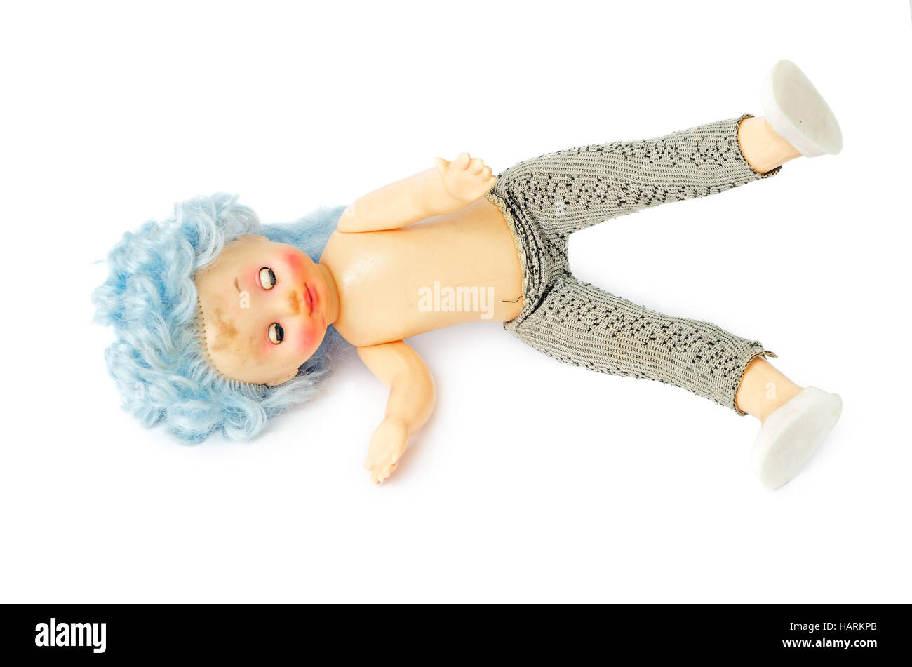 The thrown-out old dirty plastic doll with blue hair isolated on white background. Lies on one side with сlosed eyes. Stock Photo