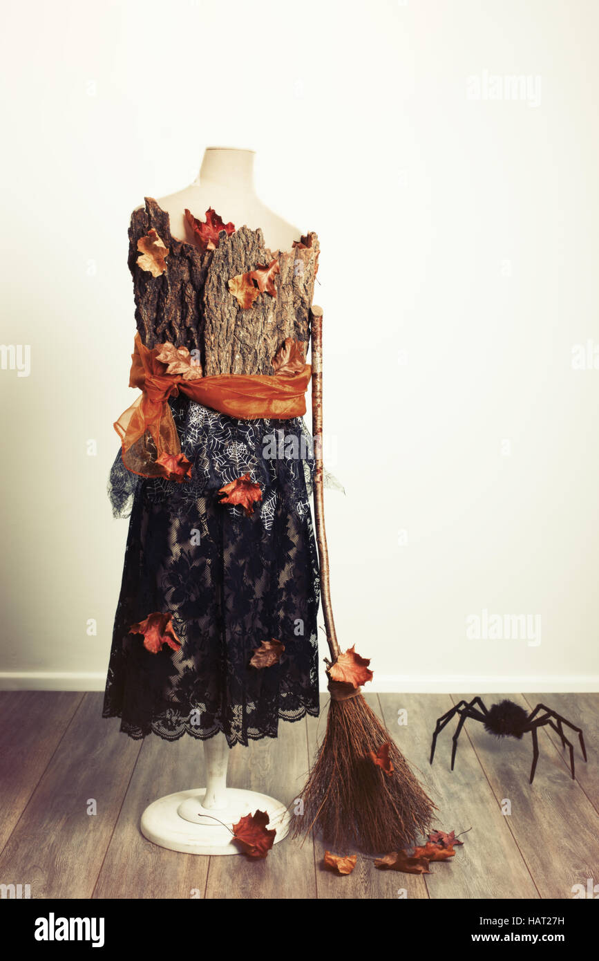 Halloween mannequin with fall leaves, witches broom and giant spider Stock Photo