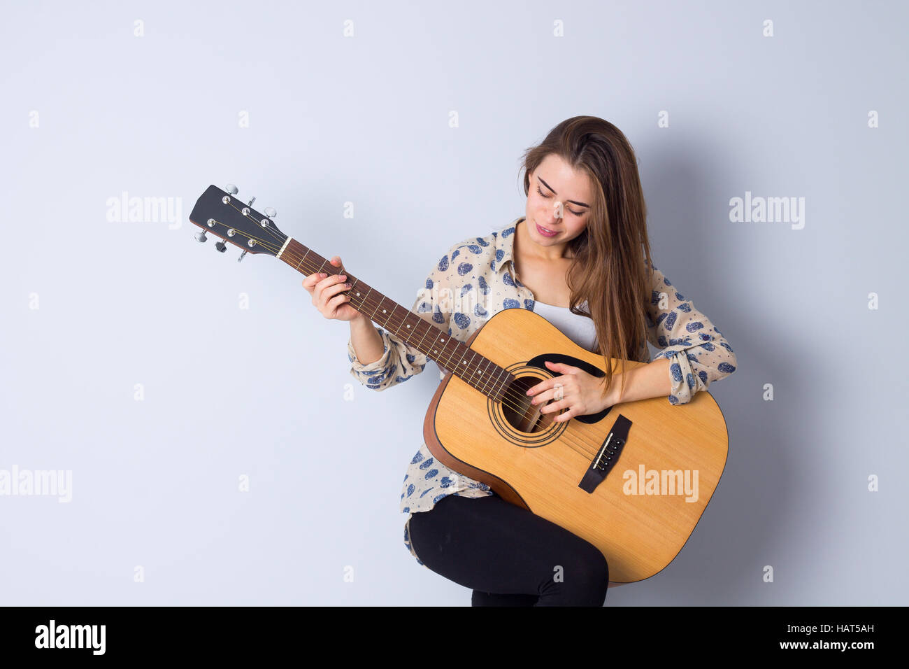 Young woman holding a guitar Stock Photo - Alamy