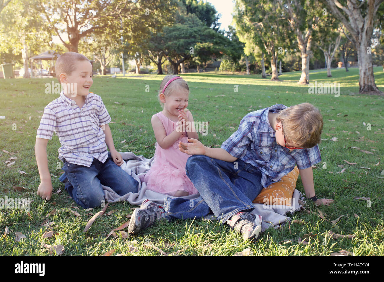 Happy brothers and sister playing at the park Stock Photo - Alamy