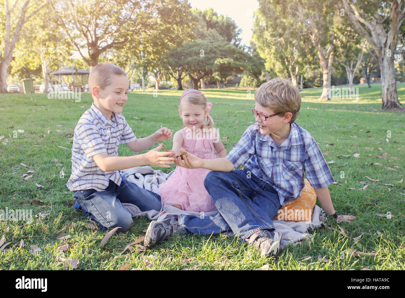 Happy brothers and sister playing at the park Stock Photo - Alamy