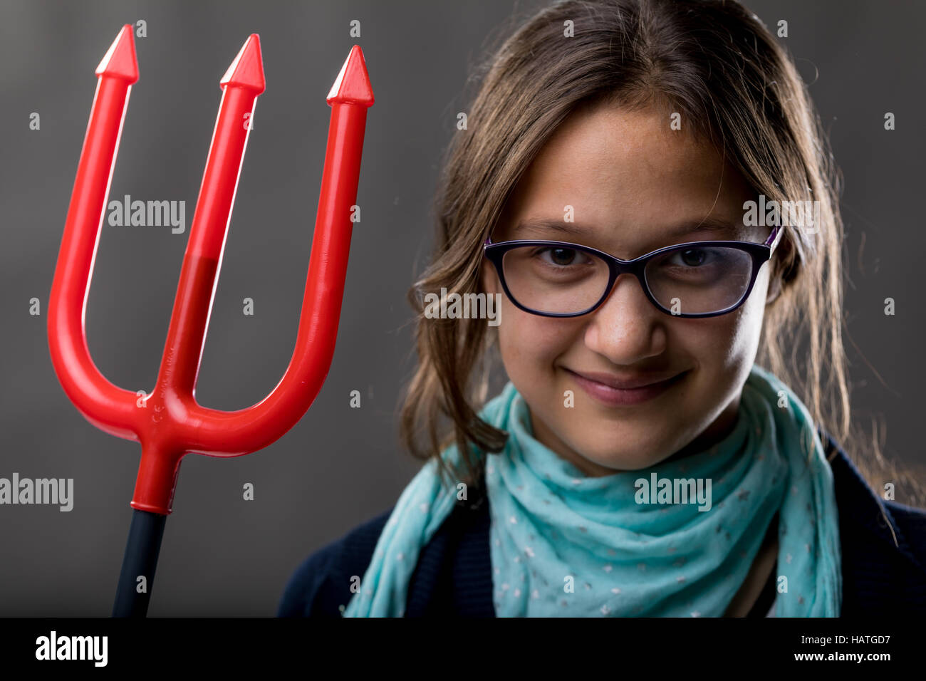 portrait of a little rascal girl with a red pitchfork meaning she is a