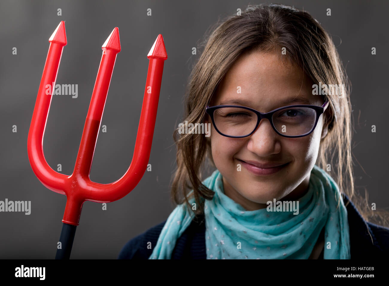 portrait of a little rascal girl with a red pitchfork meaning she is a