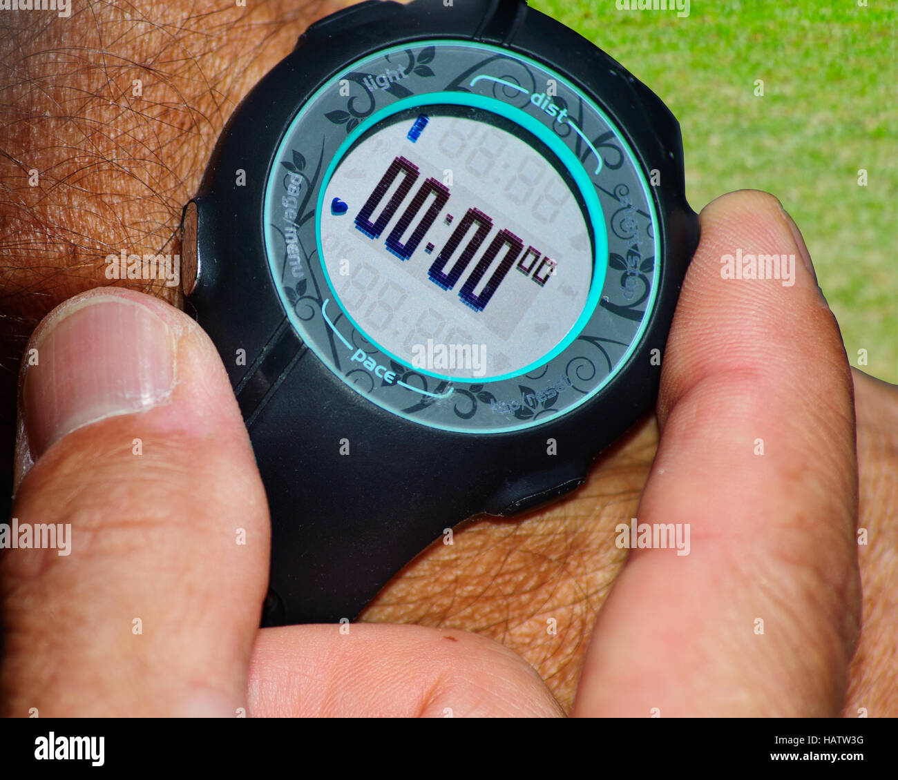 Runner's fingers starting the stopwatch on wrist Stock Photo Alamy