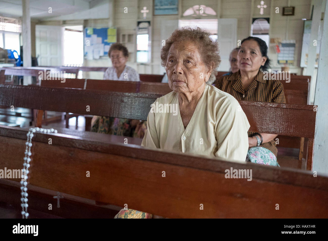 Catholics attend evening prayers at St Peter's Chapel, a small wooden building in Dalat, Mukah Division, Sarawak, Malaysia. Stock Photo