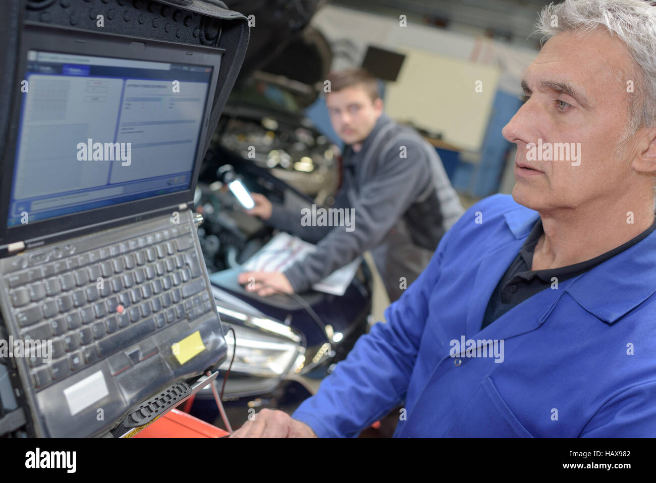 auto mechanic teacher and trainee performing tests at mechanic school