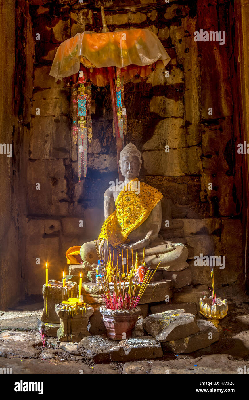 Statue of Buddha wrapped in silken robe inside the main temple at the ancient, 12th century religious site of Angkor Wat. Stock Photo