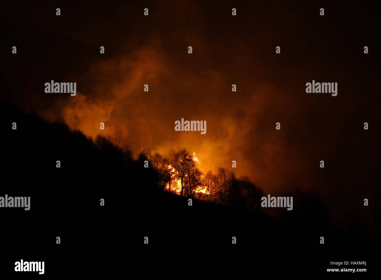 Forest fires spreading through mountains above Isone, in Switzerland Stock Photo