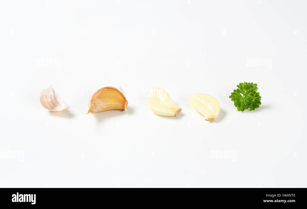 Unpeeled garlic clove and slices on white background Stock Photo