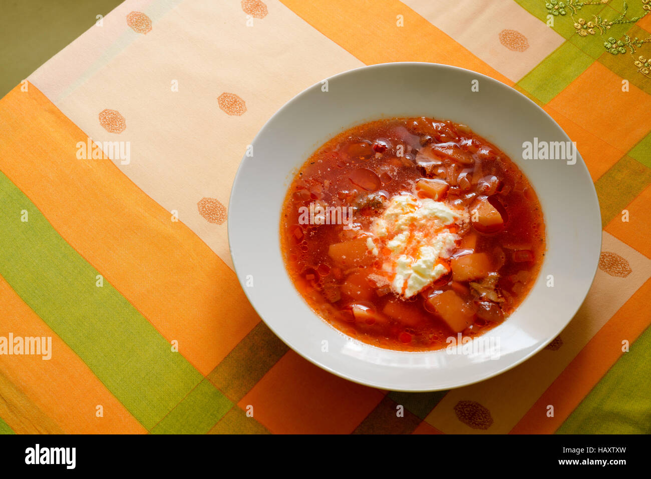 Simple traditional homemade red Ukrainian Borscht with smetana cream in a white porcelain plate Stock Photo