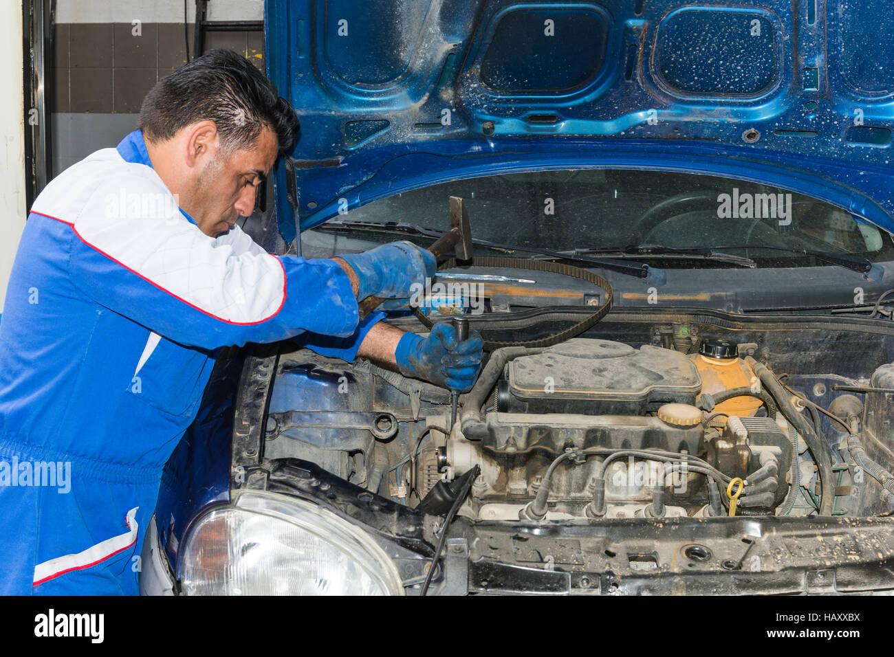 Car mechanic fixing an engine in his garage. copy space Stock Photo - Alamy
