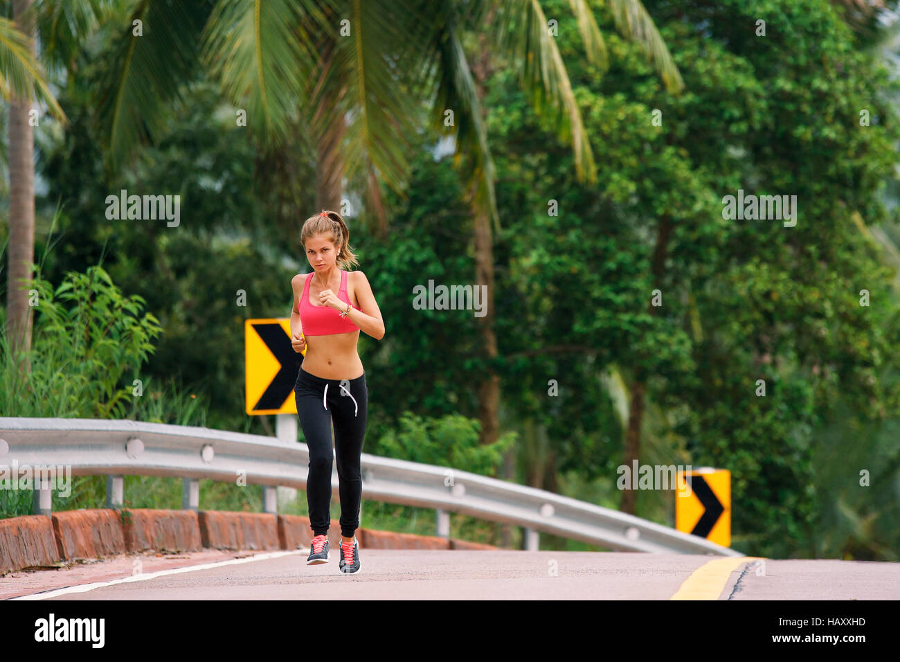 young fitness woman running at tropical forest trail Stock Photo - Alamy