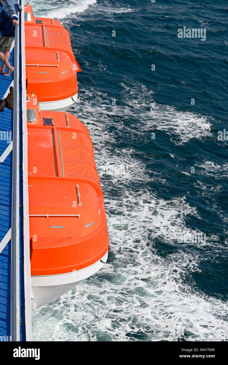 Two orange life boats on a ferry on sea Stock Photo