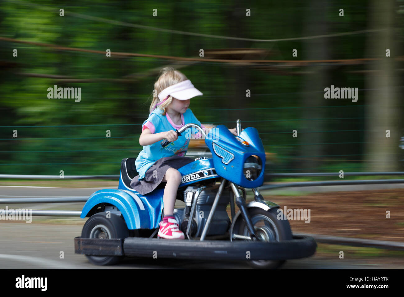 Girl riding a toy motorbike Stock Photo