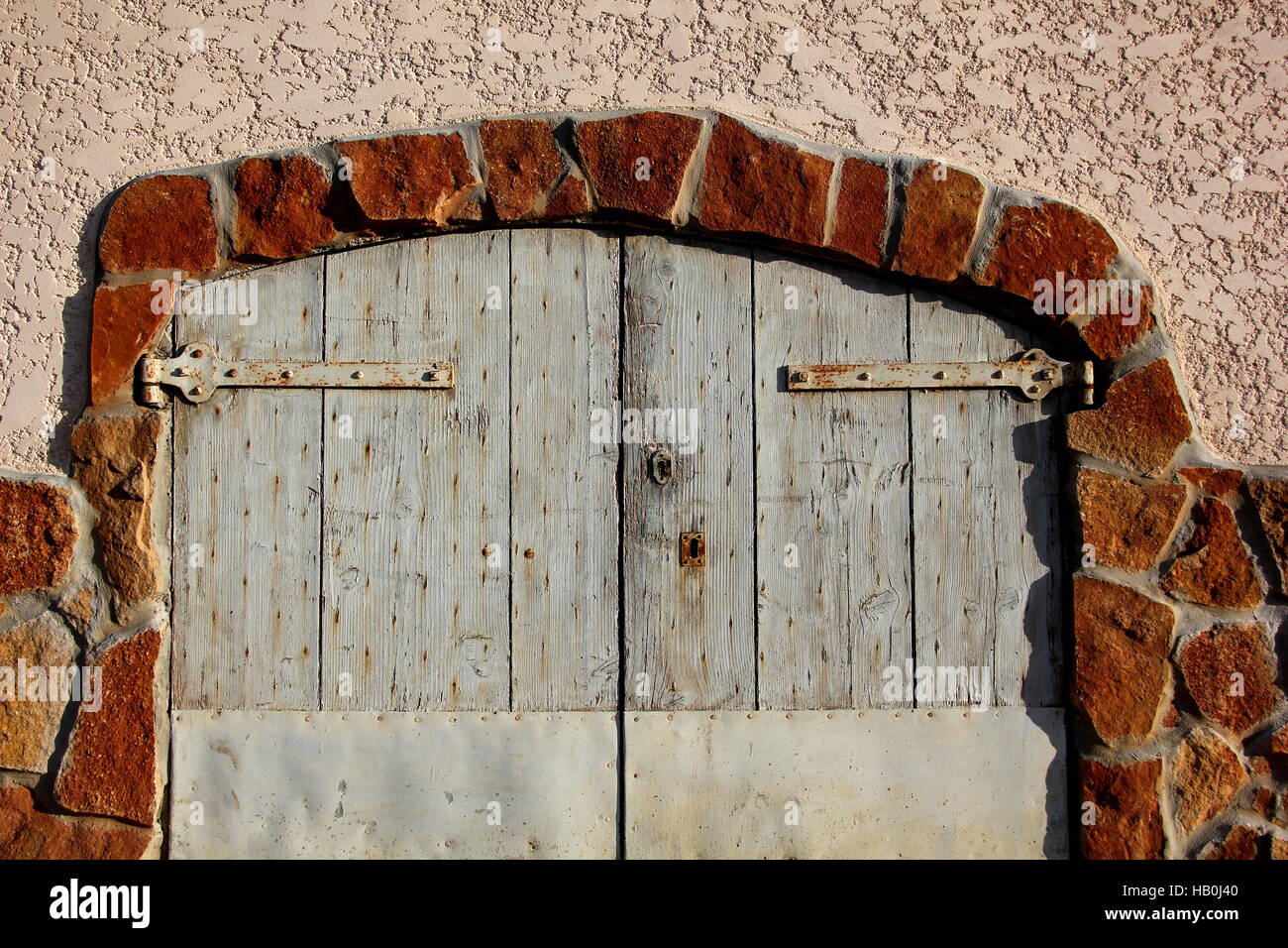 blue wooden door with a red brick wall as a frame Stock Photo