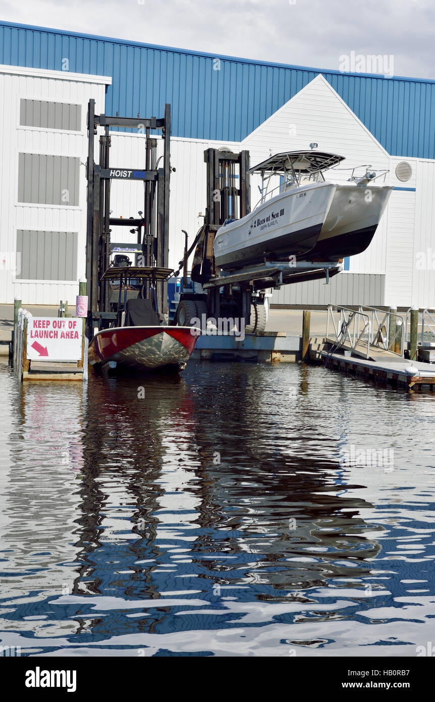 Launching speedboat and twin hulled fishing boat using fork lift truck at Four Winds Marina, Pine Island, Florida Stock Photo